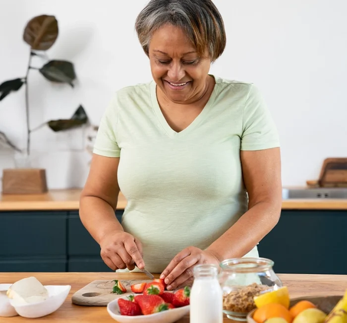 Woman preparing healthy food as part of a balanced blood sugar lifestyle.